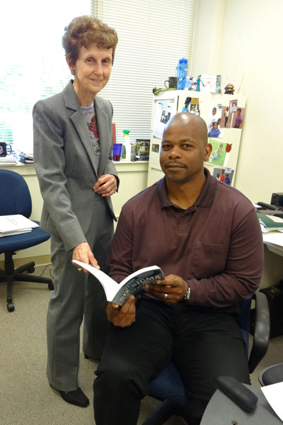 Dr. Peggy Hays, left, and Dr. Sampson Gholston examine a book on using Lean Six Sigma in healthcare in Dr. Gholston’s office.