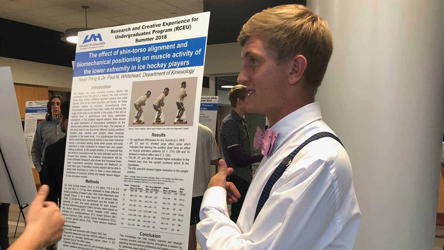 Noah Pring standing by his presentation during the College of Education’s Research Day