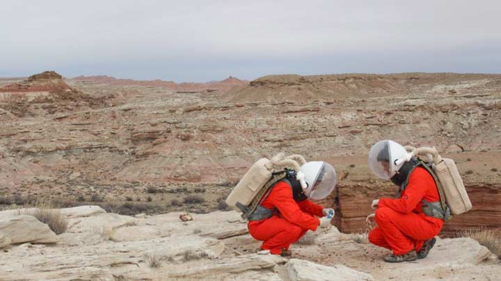 crewmembers wearing space suits and life support systems