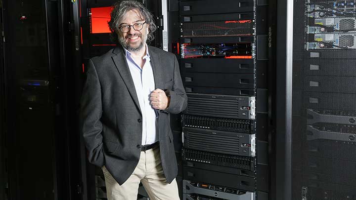 Dr. Jerome Baudry posing in front of computer servers