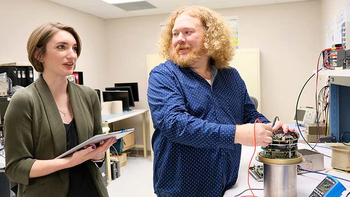 Sarah Stough and Dr. Daniel Walker in a lab. ?>