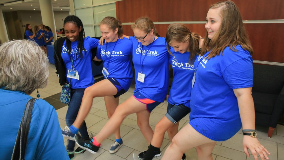 girls smiling and laughing in motion while forming a kickline