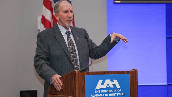 Ron Ross speaking at a podium.