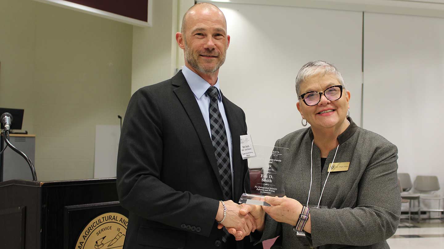 Eric Smith and Pam Horn shaking hands.