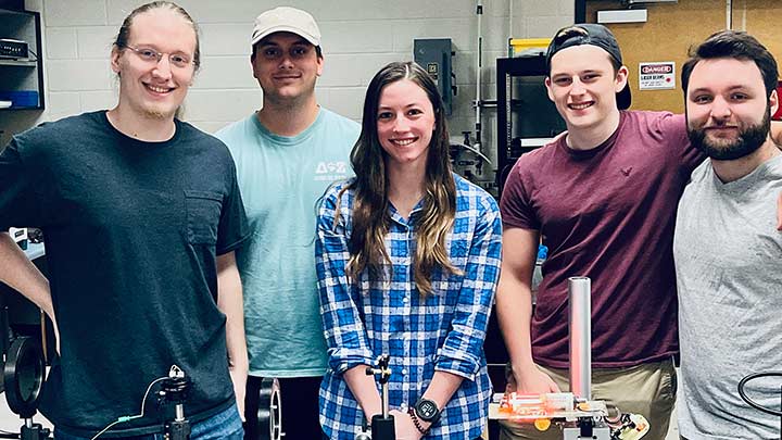 Five students posing in a lab.