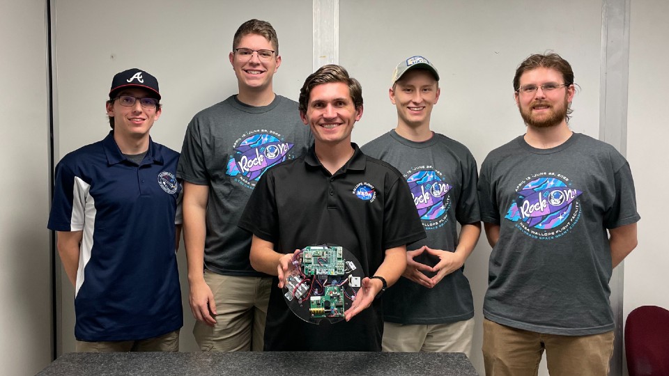 uah space hardware club members holding a payload