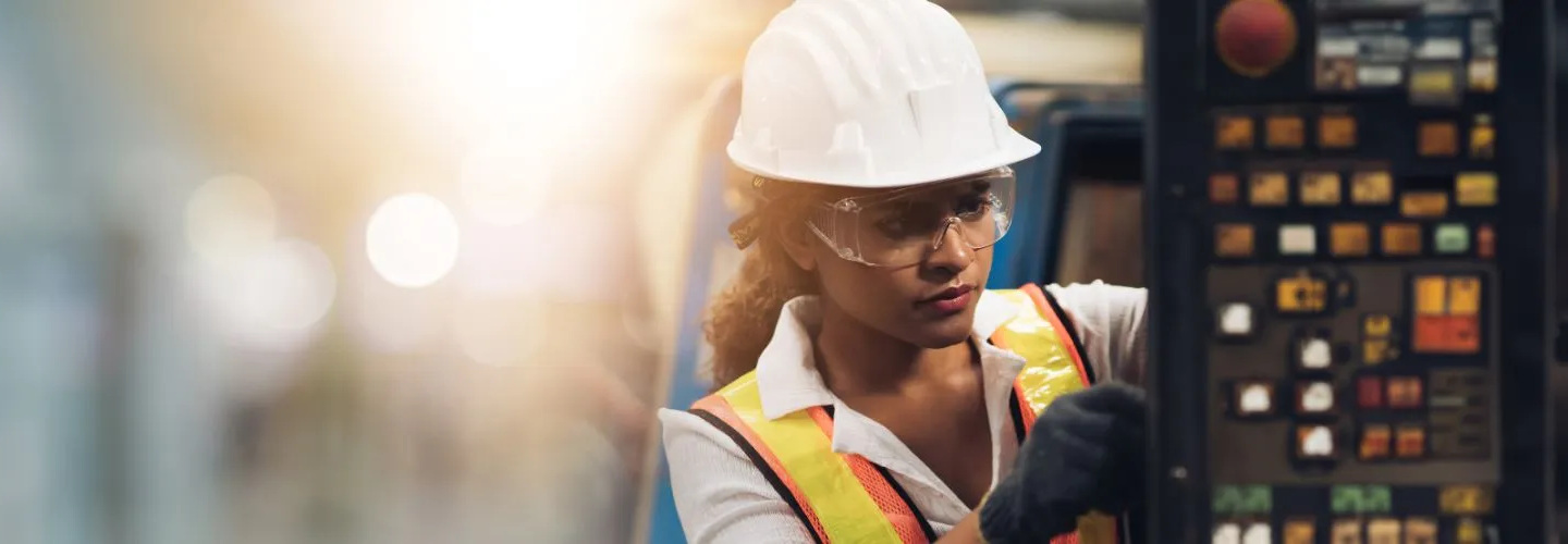 Worker in safety wear examining a switch baord Worker in safety wear examining a switch baord