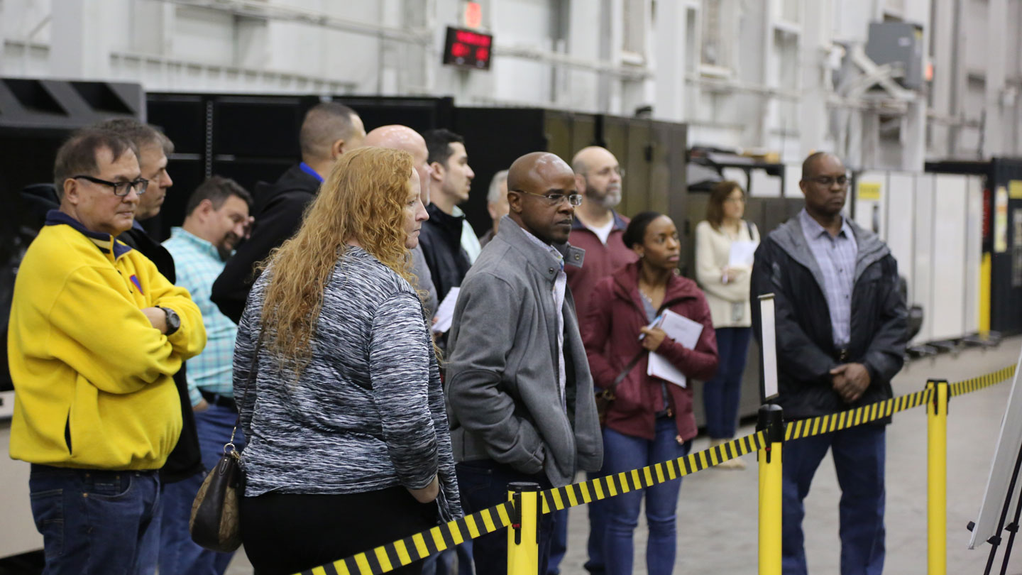 Technical professionals tour a facility.