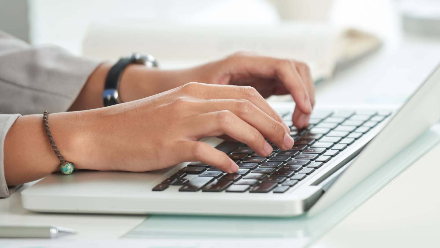 hands working on a laptop