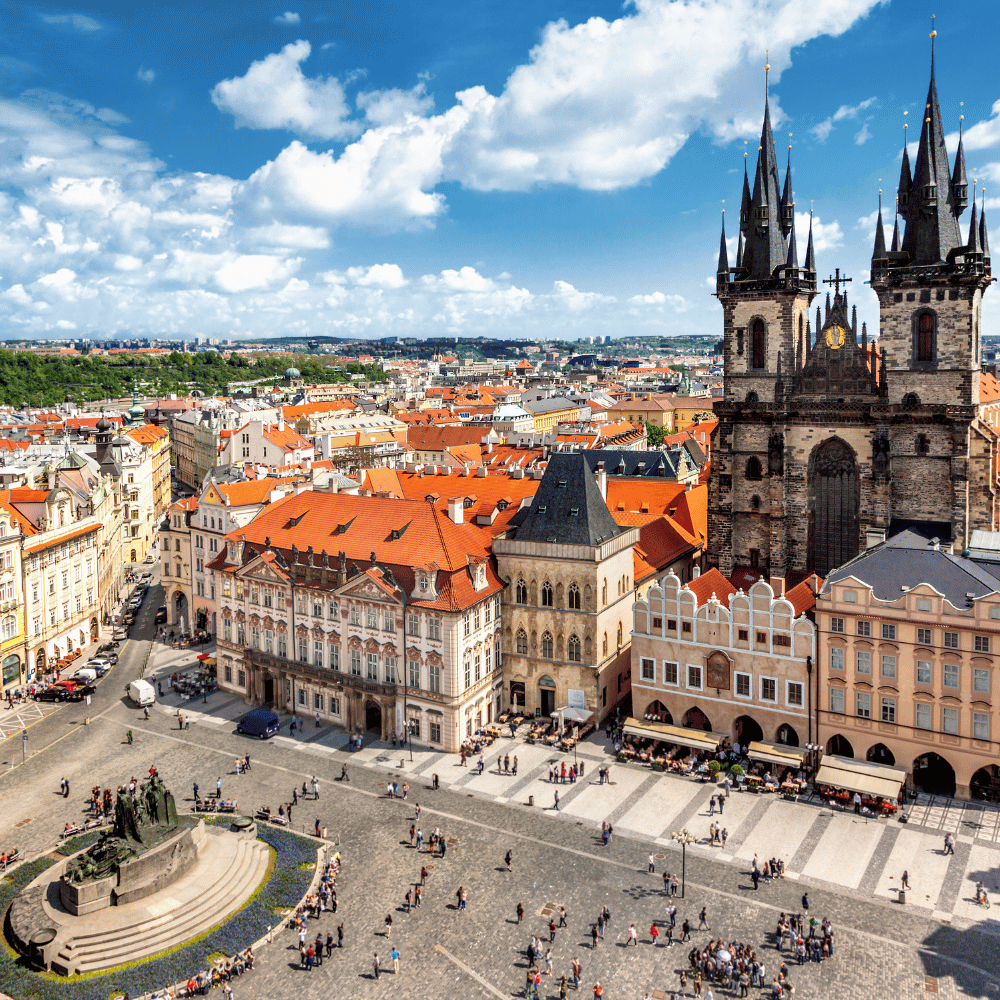 Aerial view of Old Town Square with the Gothic spires of Church of Our Lady before Týn and the Jan Hus Monument below.