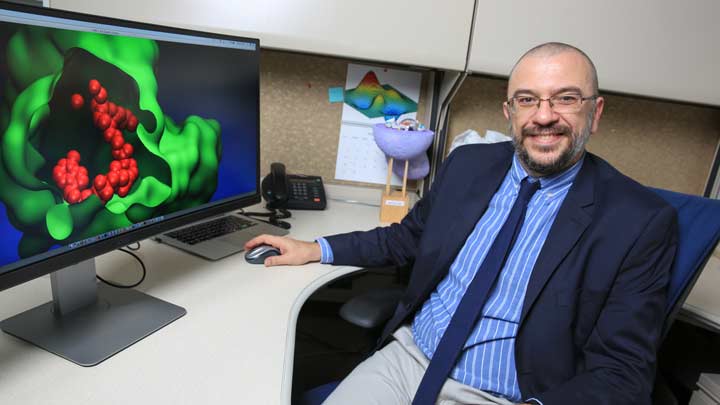 Dr. Jerome Baudry at desk with computer.