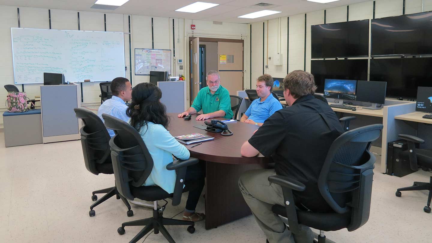 CSIL Faculty / Staff setting around a table during a meeting in their lab.