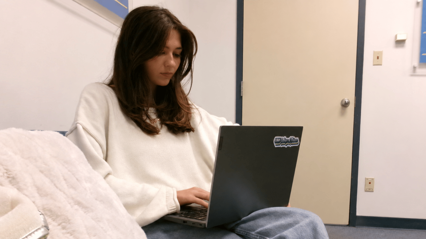 Cyber Operations Technology student works from a laptop in a study area.